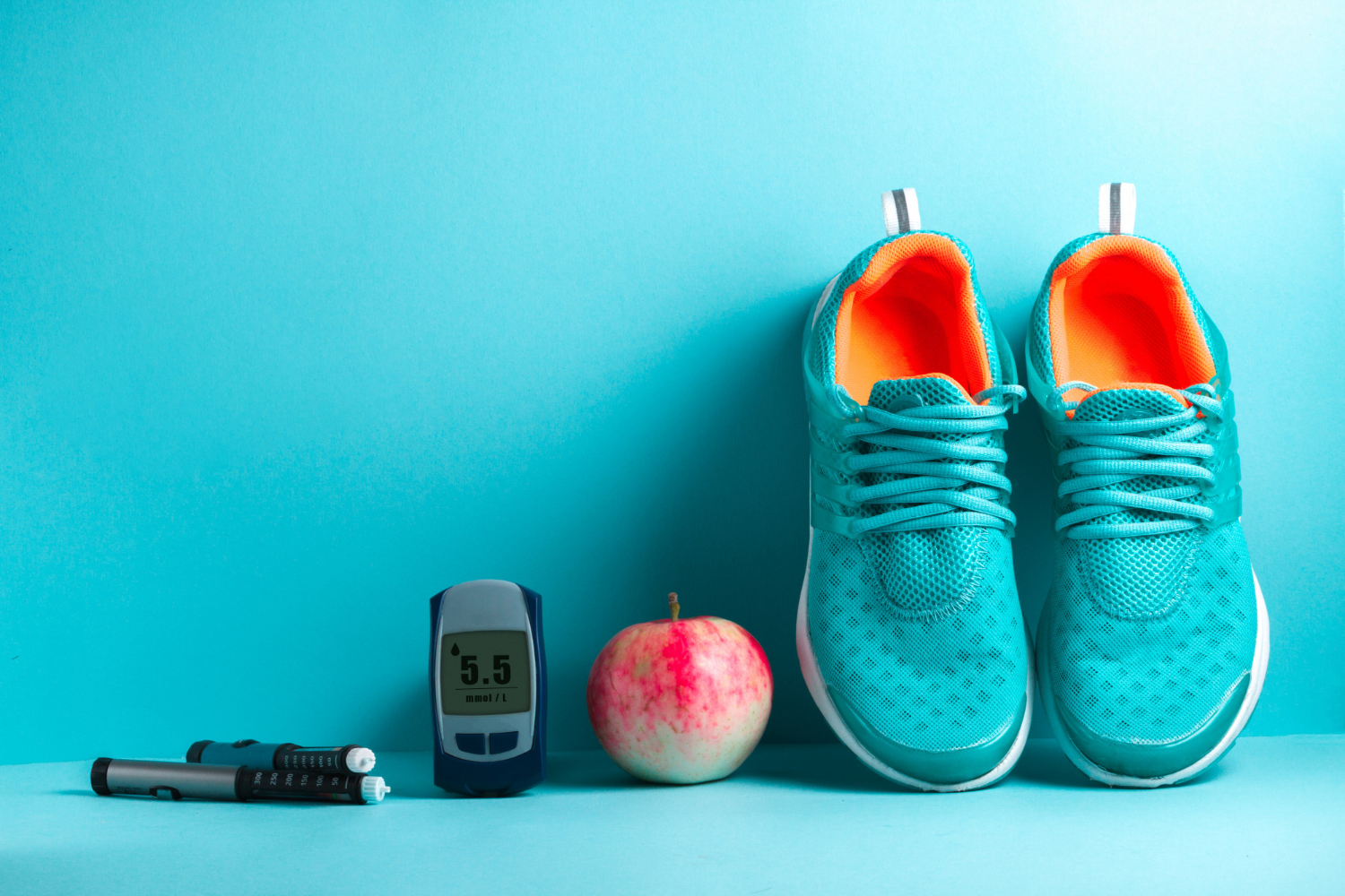 11 Blue sneakers, a red apple, a glucose meter, and insulin pens arranged on a blue background.